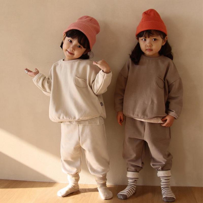 Two kids wearing basic sweatshirt sets and beanies