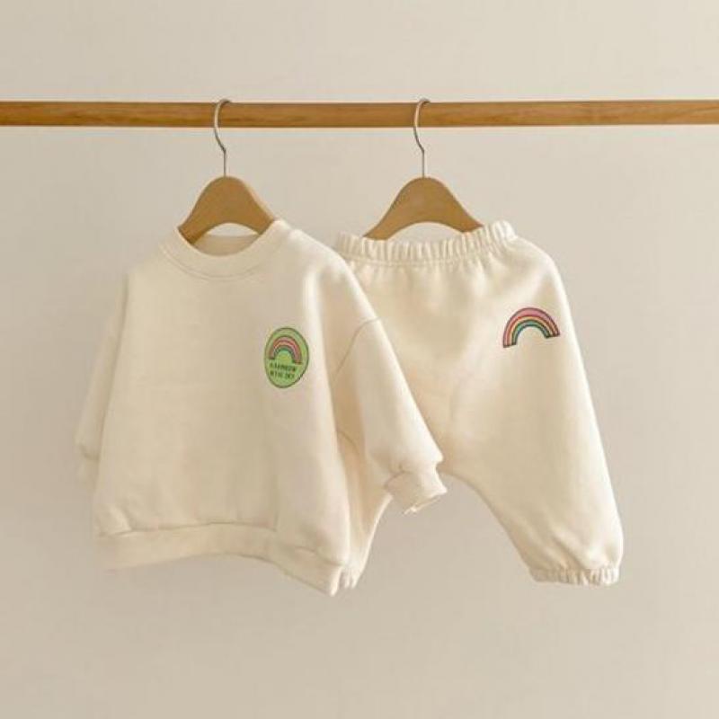 White rainbow sweatshirt and pants hanging
