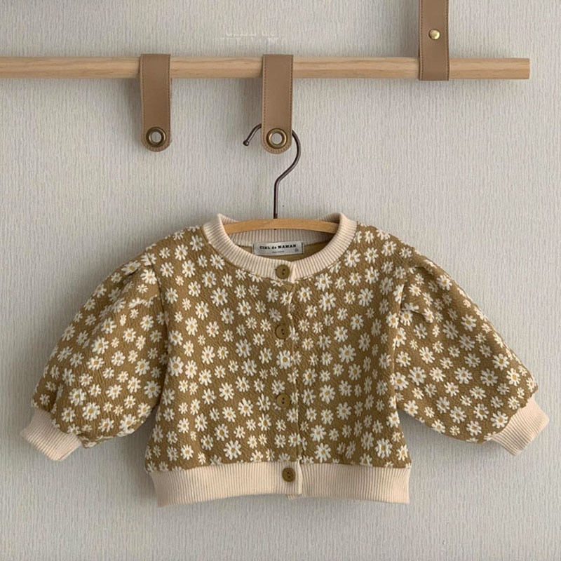 Yellow daisy knit cardigan on a hanger