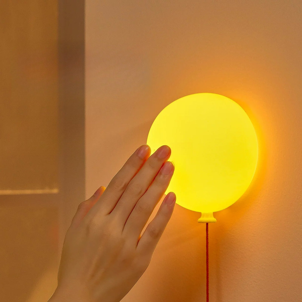 Hand tapping the balloon night light to change brightness