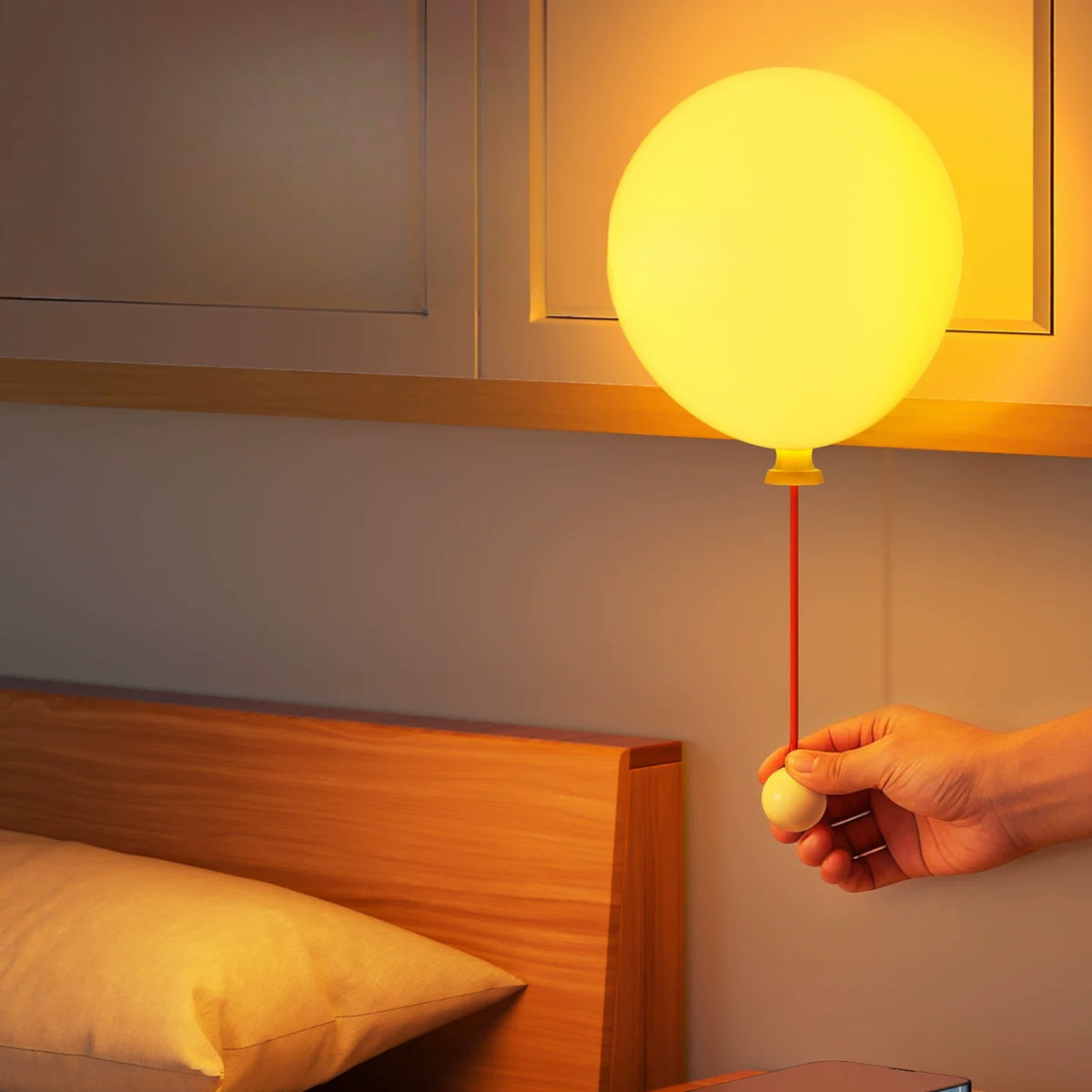 Pulling the cord to switch on the balloon night light above a bed