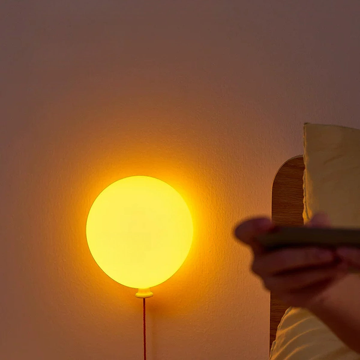 Balloon night light glowing beside the bed in a dim room