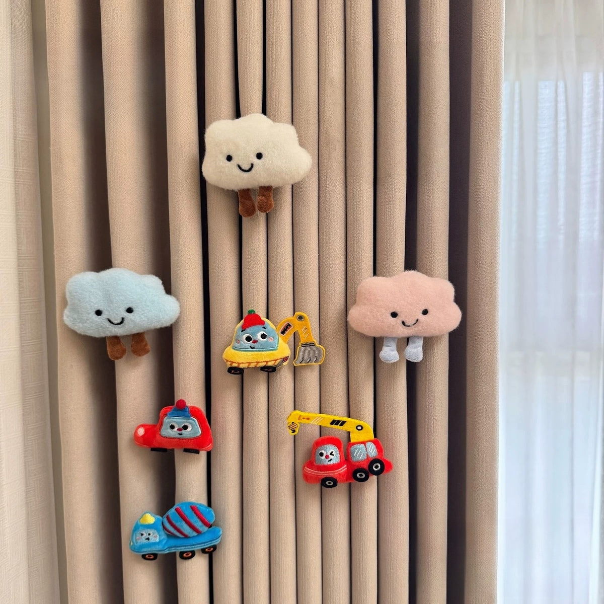 Set of seven plush curtain charms with white, blue and pink clouds and four vehicles
