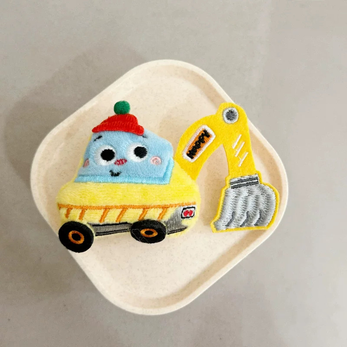 Close-up of the yellow plush excavator charm