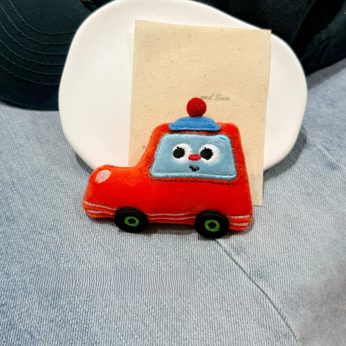 Close-up of the red plush police car charm
