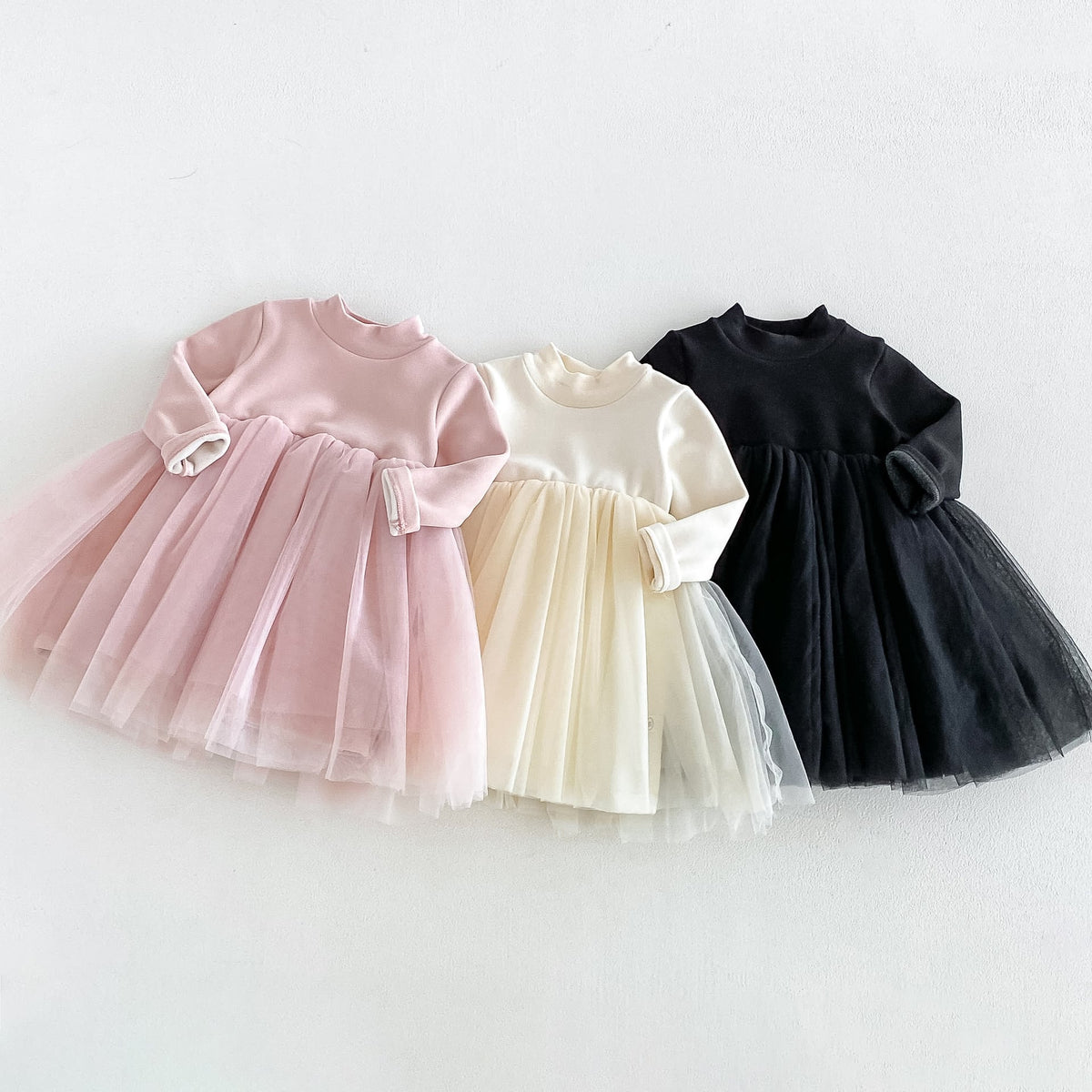 Blush, cream and black tutu dresses side by side