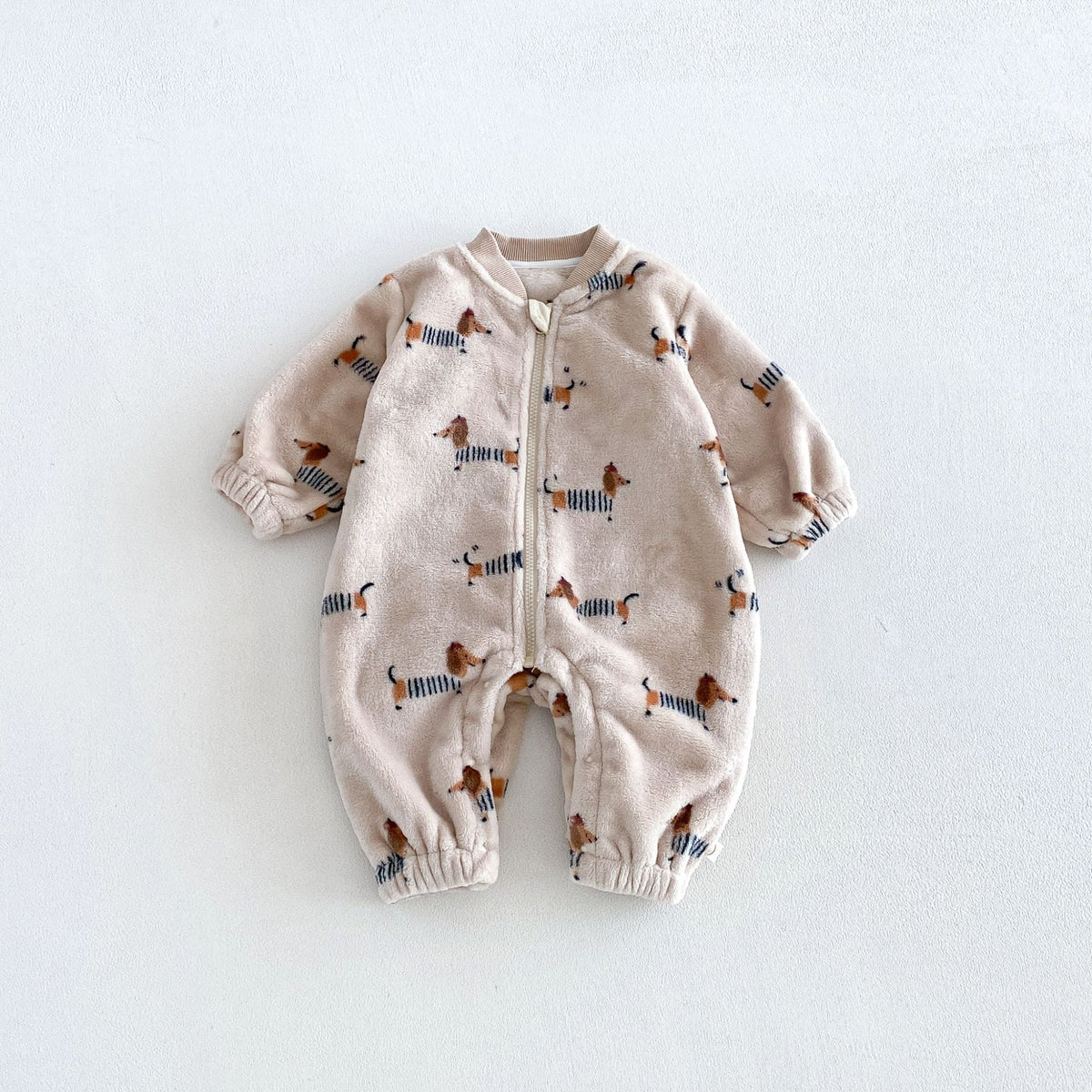 Plush baby jumpsuit covered in little striped-sweater dachshunds