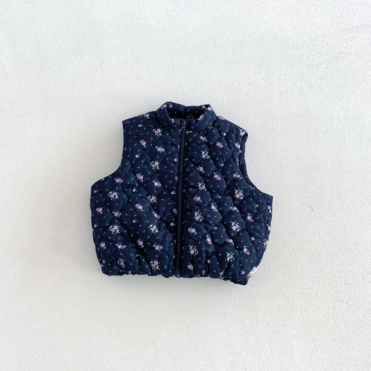 Navy floral quilted puffer vest for kids, flat lay