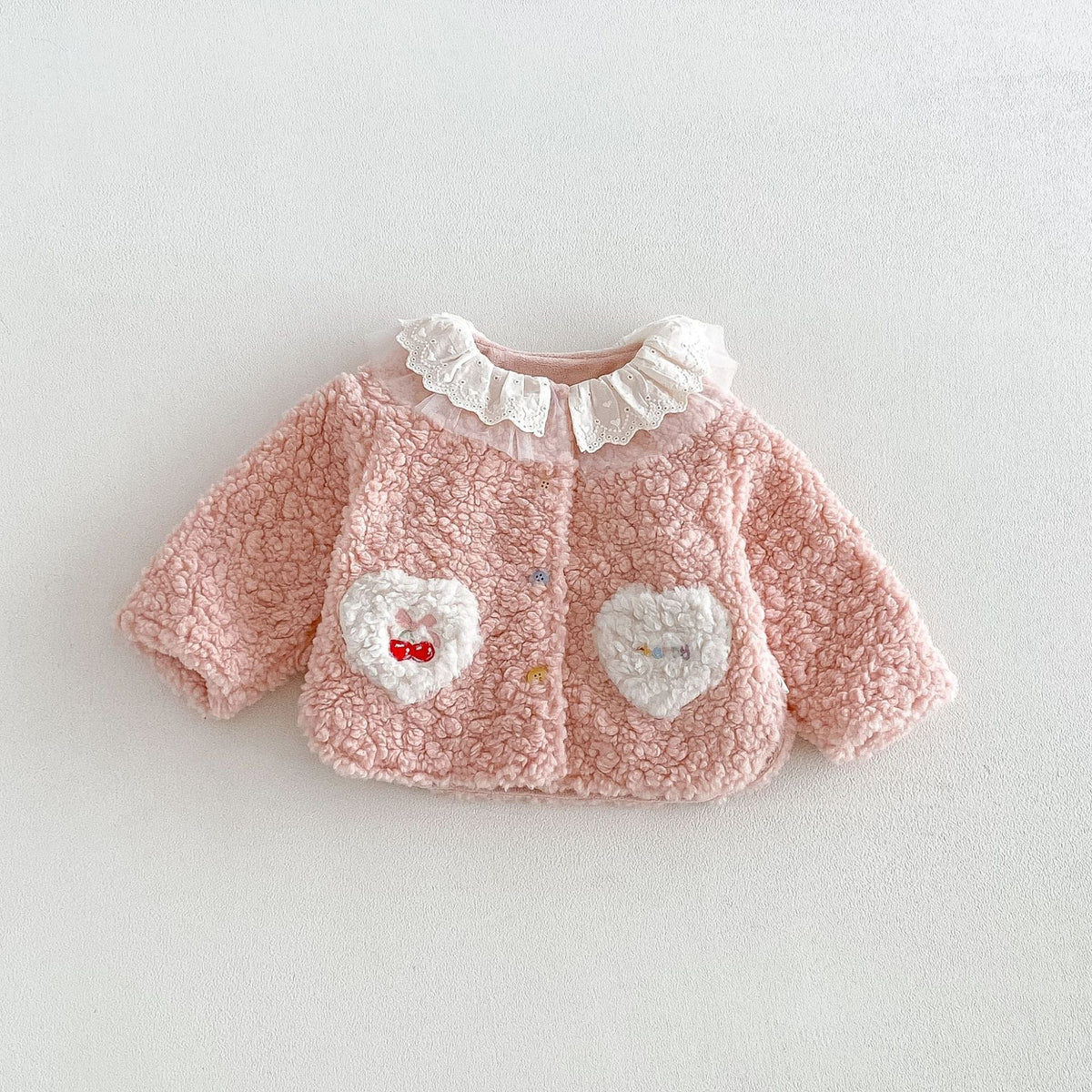 Blush pink sherpa jacket with eyelet ruffle collar and fluffy white heart pockets
