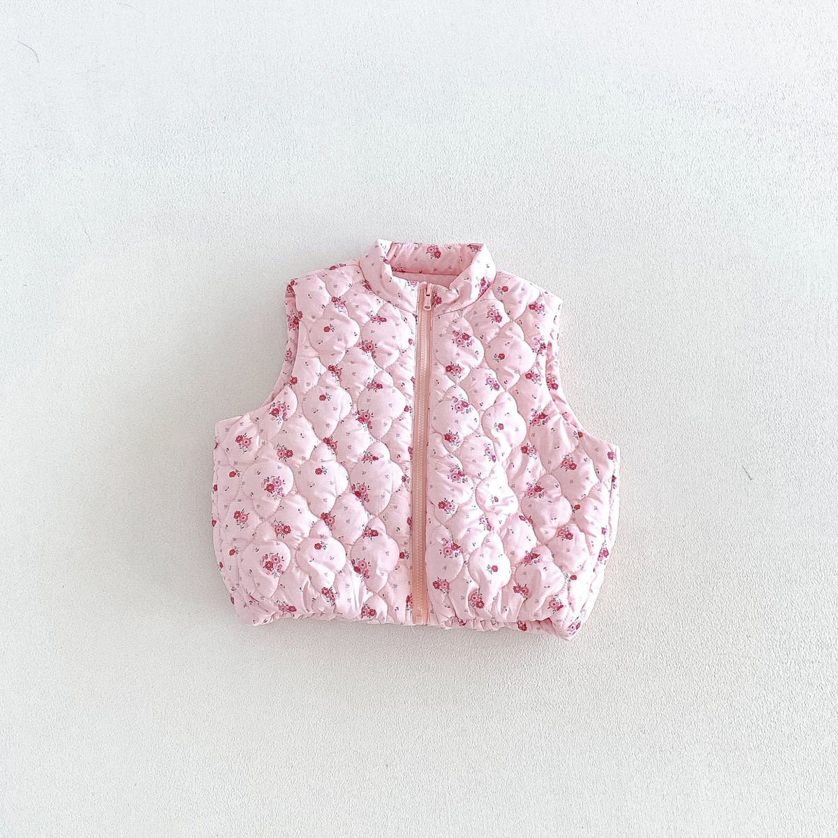 Blush pink floral quilted puffer vest for kids, flat lay