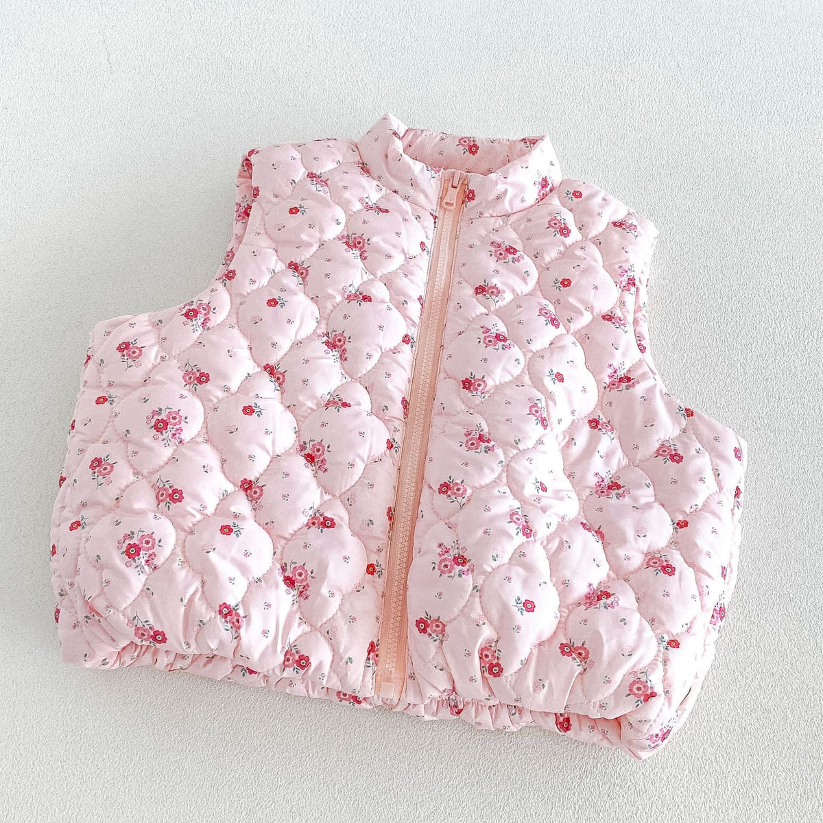 Close-up of the pink vest's bubble quilting and tiny rose print