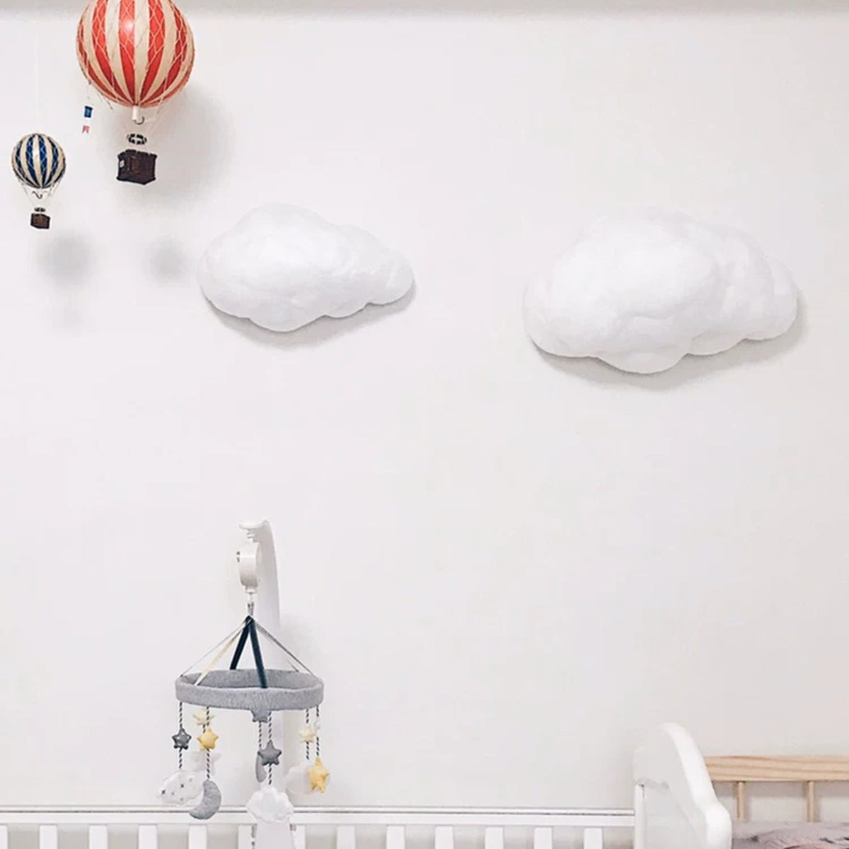 Two cloud lamps on a nursery wall in a kids room with hot-air-balloon decor