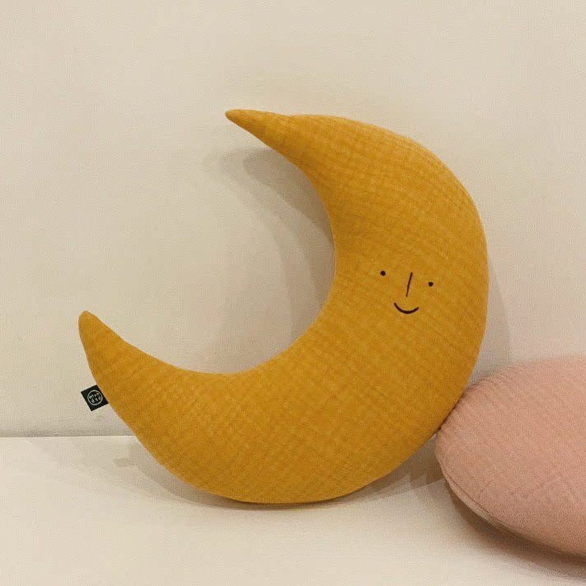 Moon cushion propped on a bed