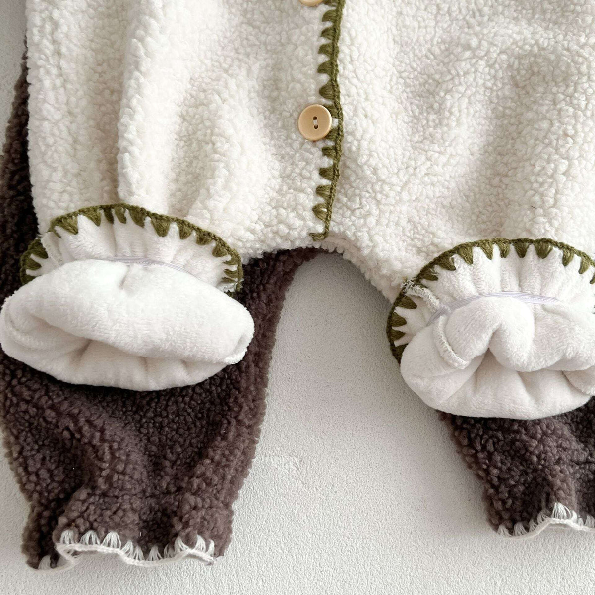 Soft plush lining inside the sherpa romper leg cuffs
