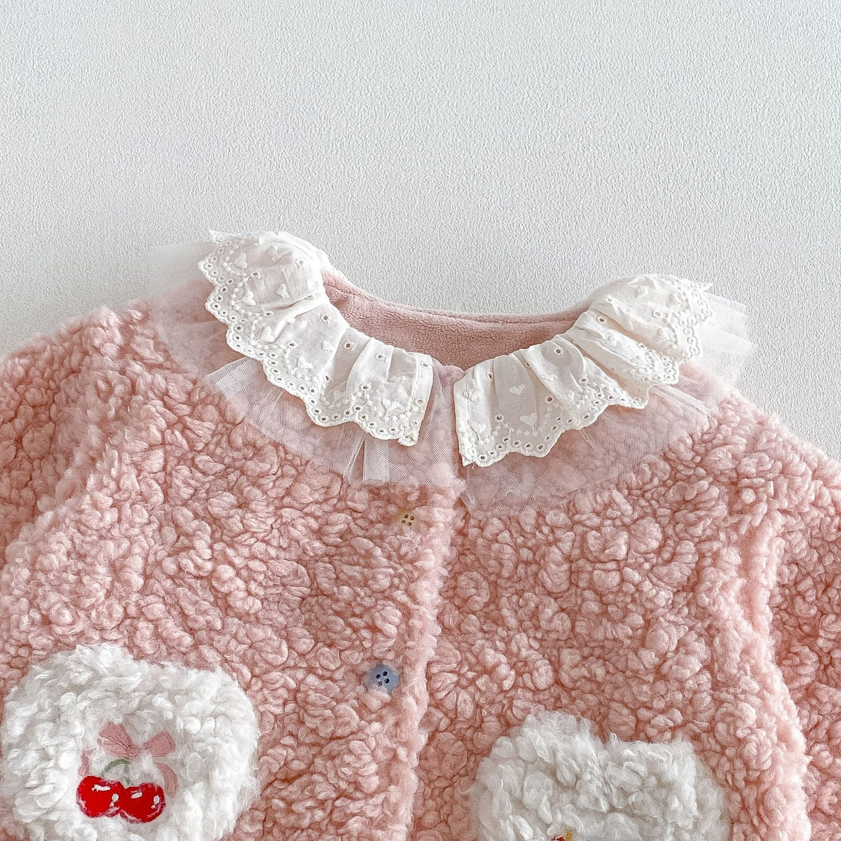 Detail of the eyelet lace and tulle ruffle collar with button front