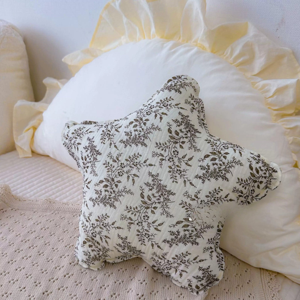 Misty Forest grey botanical print star cushion on a ruffled pillow