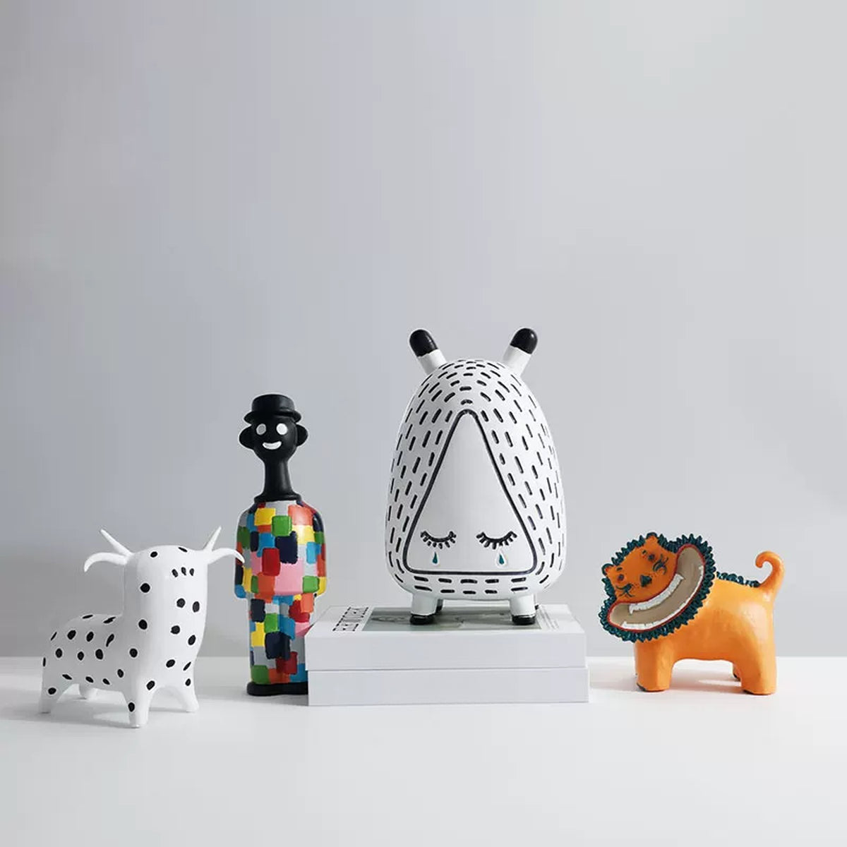 Four hand-painted character figurines on a white shelf