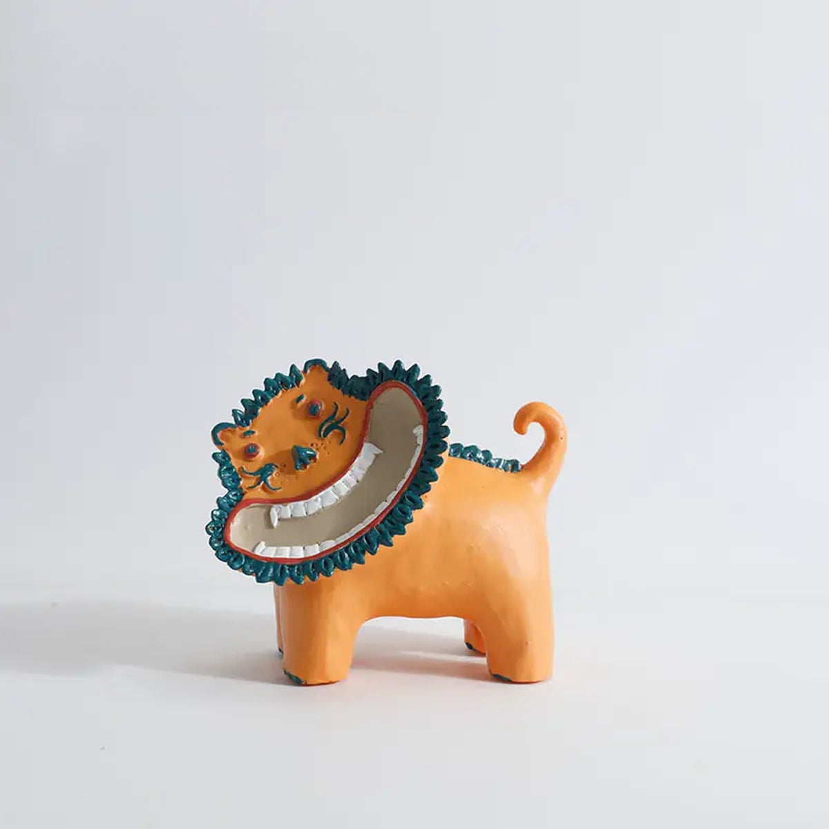 Sunny Lion figurine in orange with a big grin and teal mane