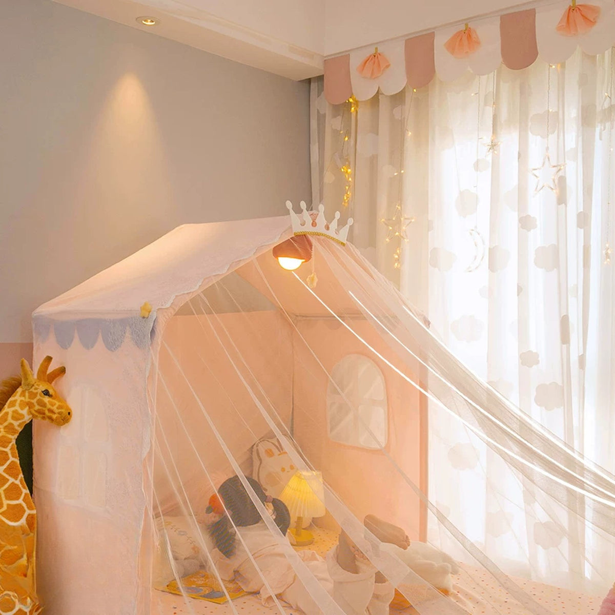 Pink cottage half-bed tent with a crown and sheer mesh canopy draped over a single bed