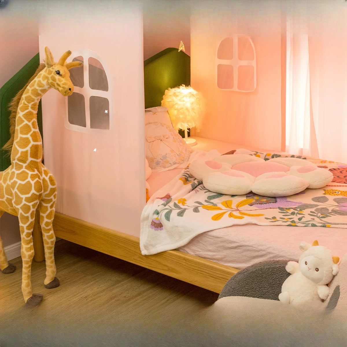Pink house bed tent with felt windows beside a giraffe plush and a cosy bed