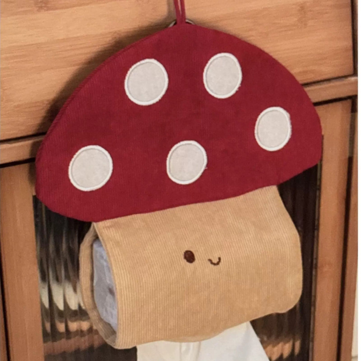 Mushroom tissue holder hanging on a wooden cabinet