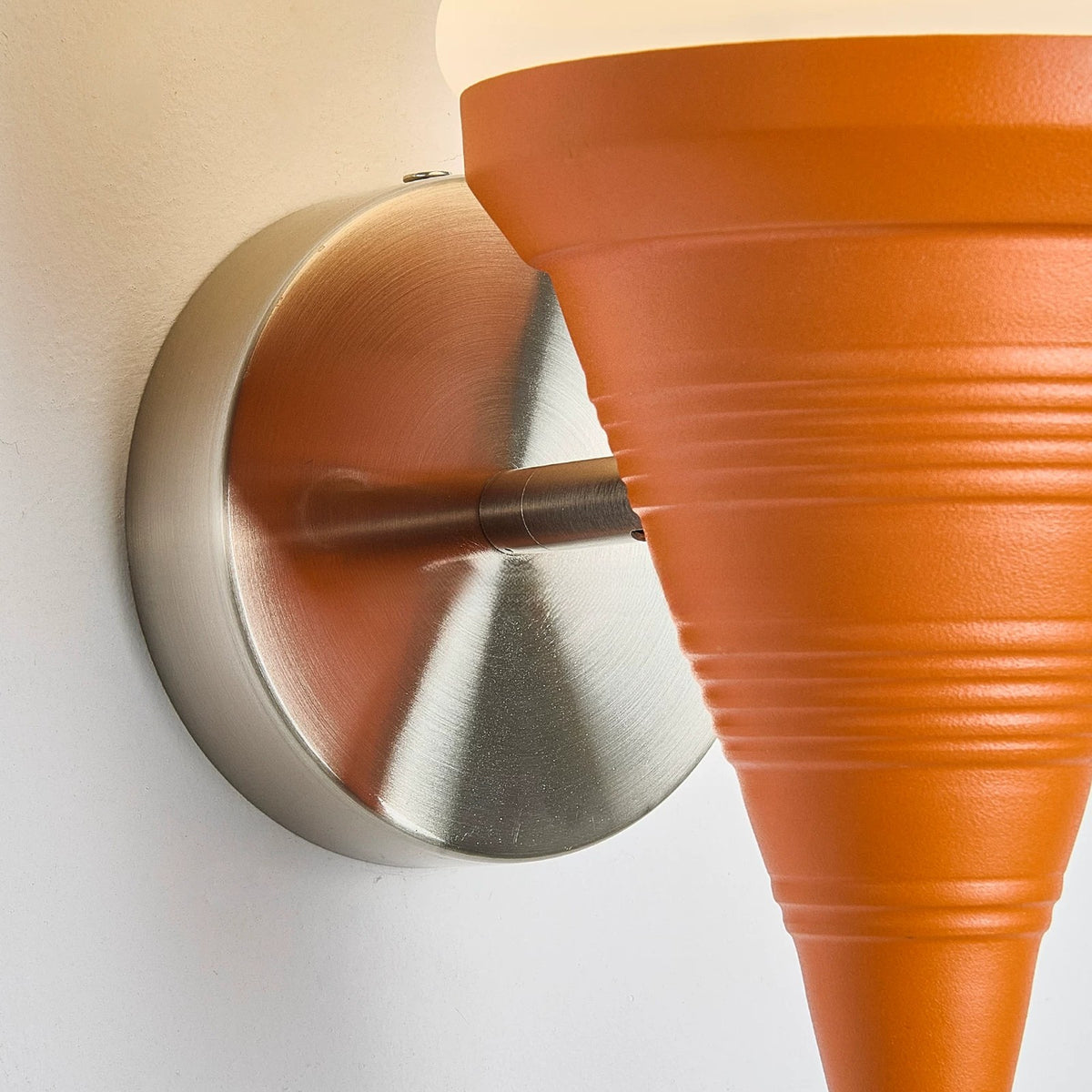 Detail of the ribbed orange cone and round brushed metal wall plate