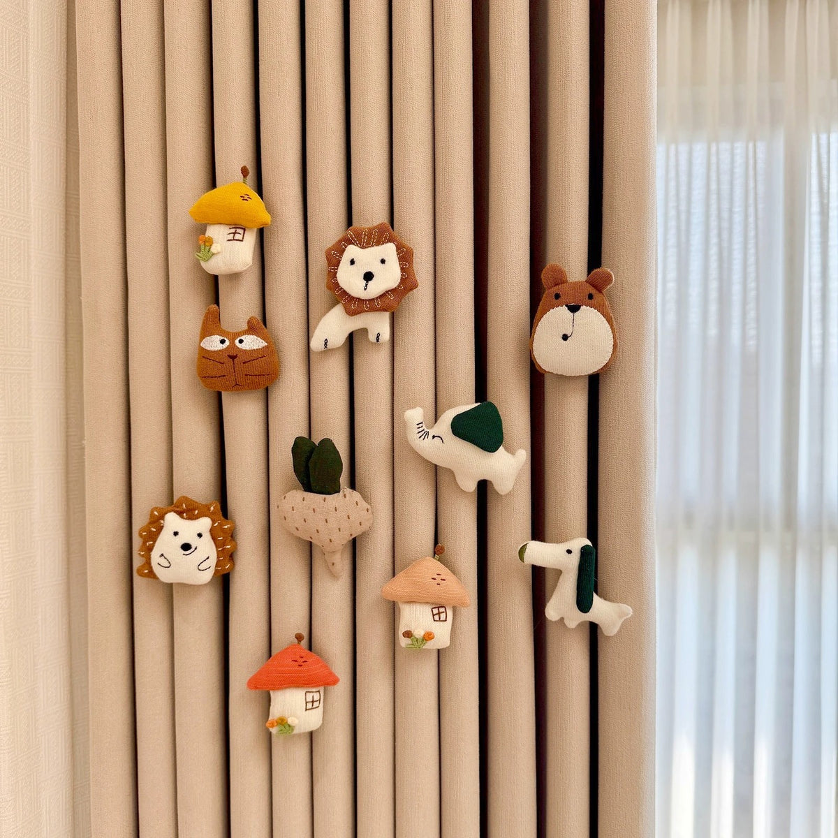 Full storybook set of fabric curtain charms pinned to beige nursery curtains