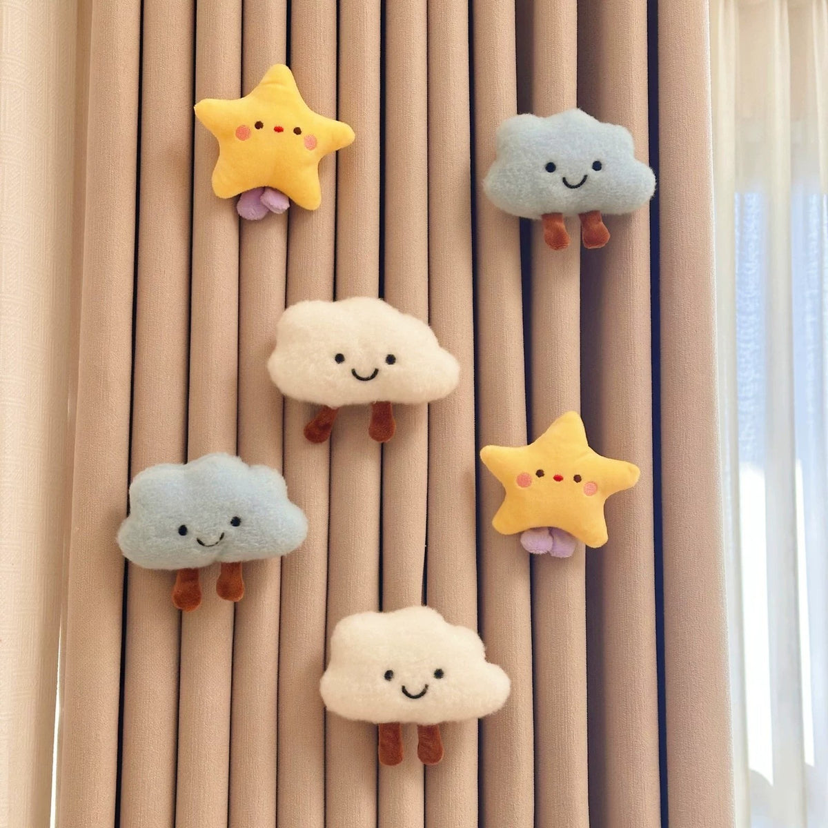 Two white and two blue plush clouds with yellow stars on a curtain