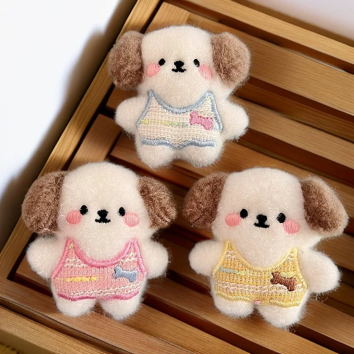 Three fluffy plush puppy charms with floppy brown ears