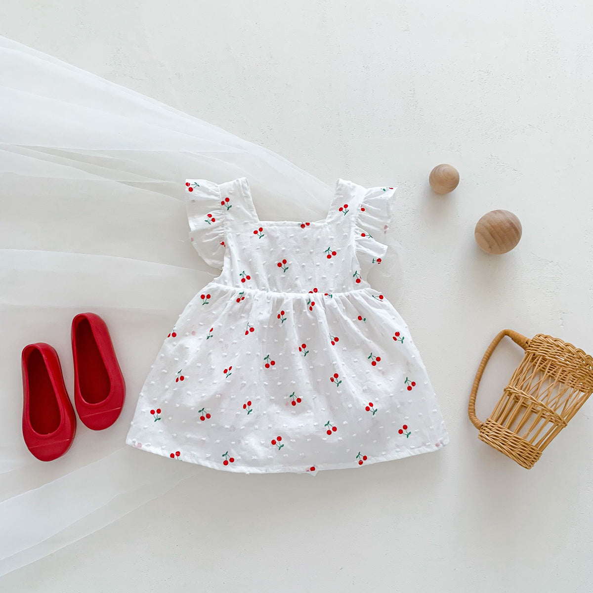 Cherry print flutter dress with swiss dot fabric styled with red shoes