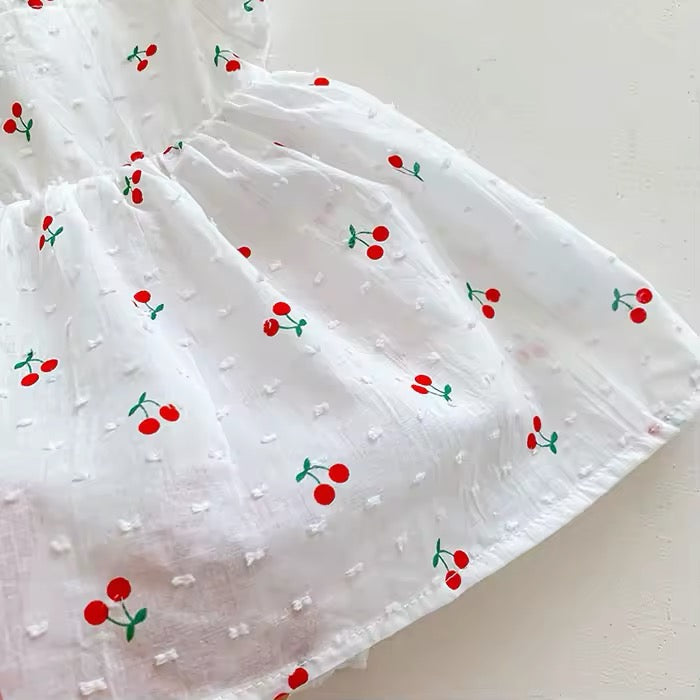 Cherry print swiss dot fabric close-up on baby girl flutter dress