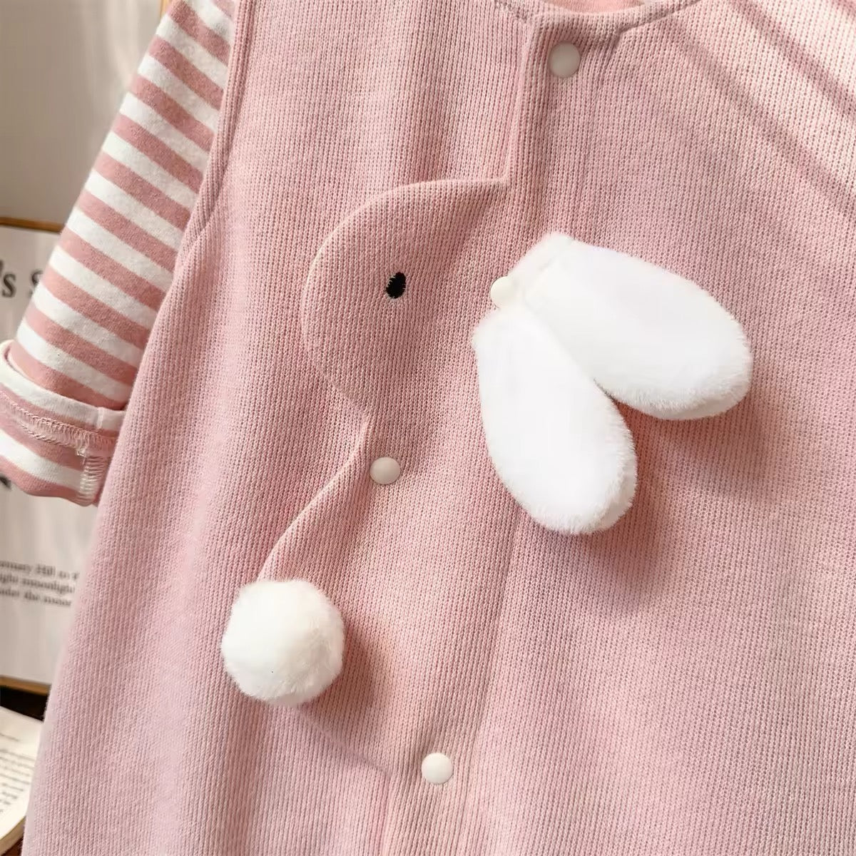 Pink knit jumpsuit with 3D fluffy bunny ear and tail appliqué detail