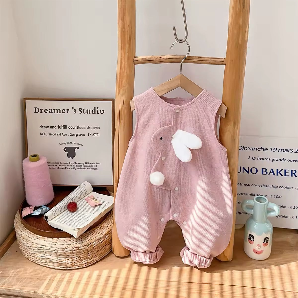 Sleeveless pink knit baby jumpsuit with ruffled bunny ear collar