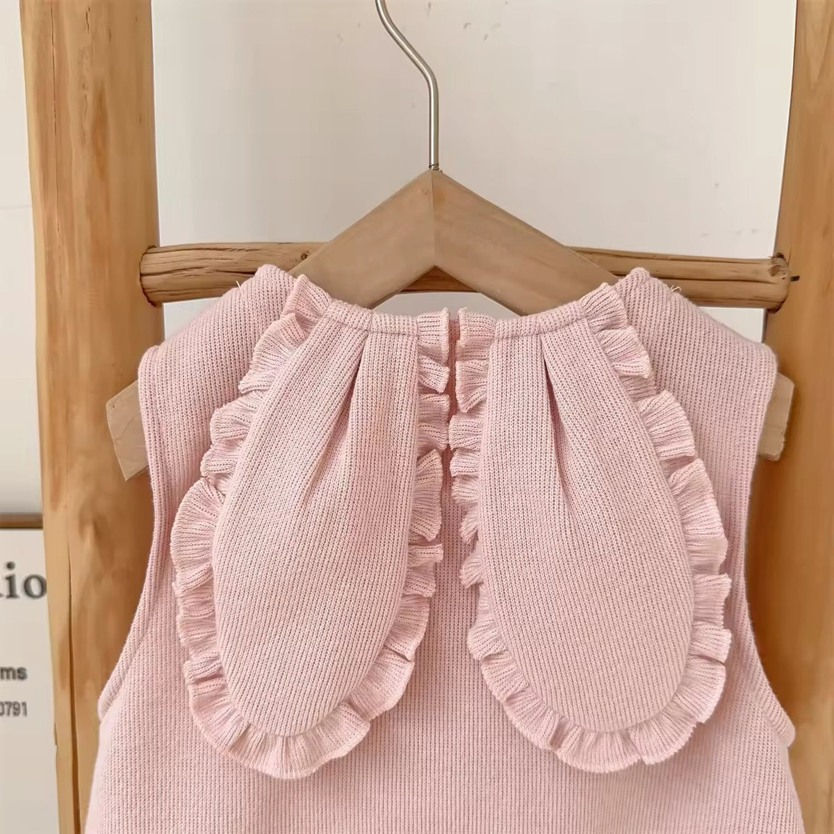 Bunny ear appliqué and snap button placket on pink baby jumpsuit