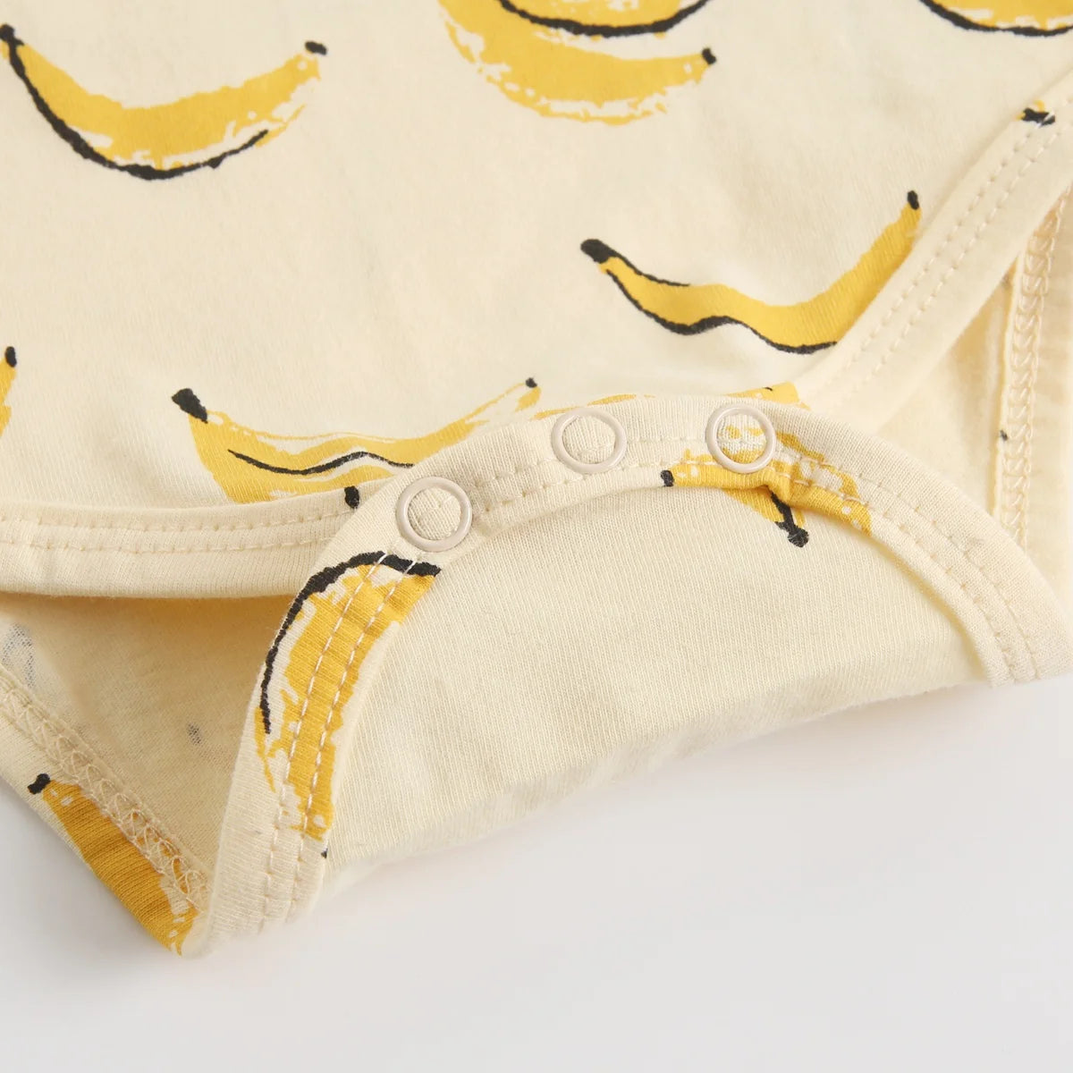 Banana print baby bodysuit snap closure detail for easy diaper changing