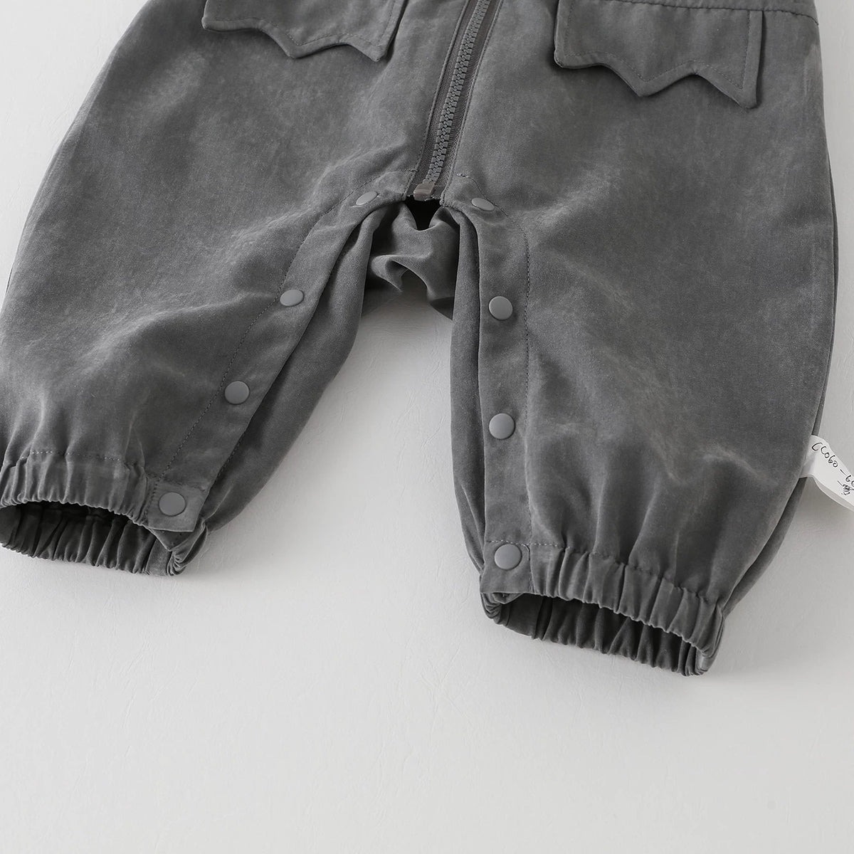 Snap legs and elastic ankle cuffs on the grey baby romper