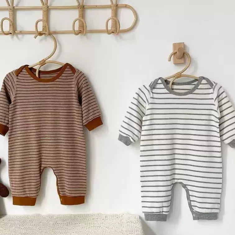 Striped baby rompers hanging on a wooden hook rail