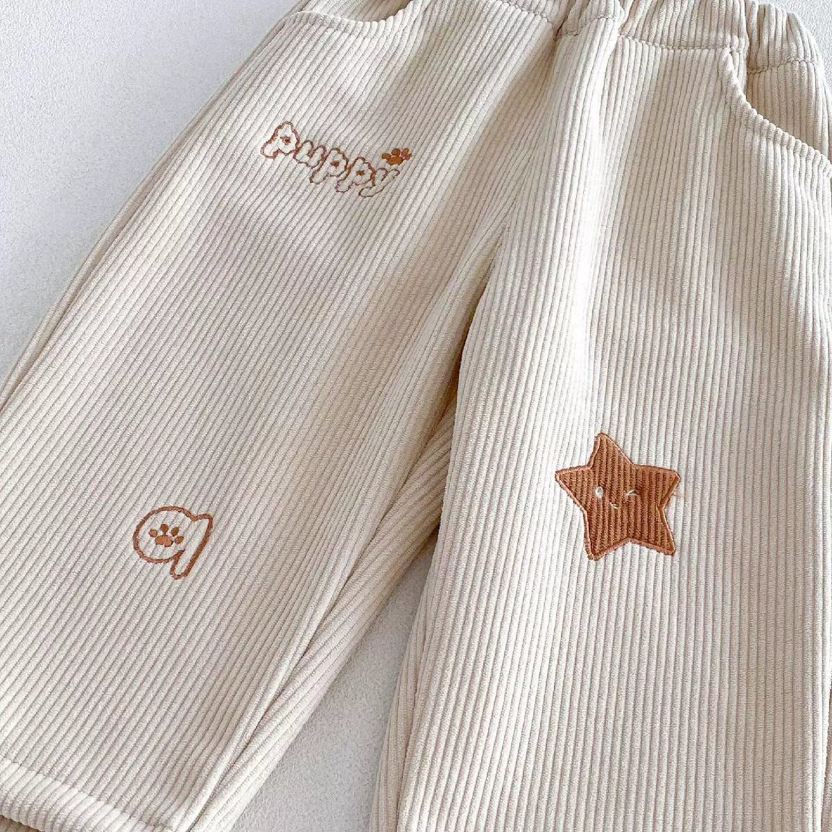 Close-up of the embroidered star and puppy detail on cream cord