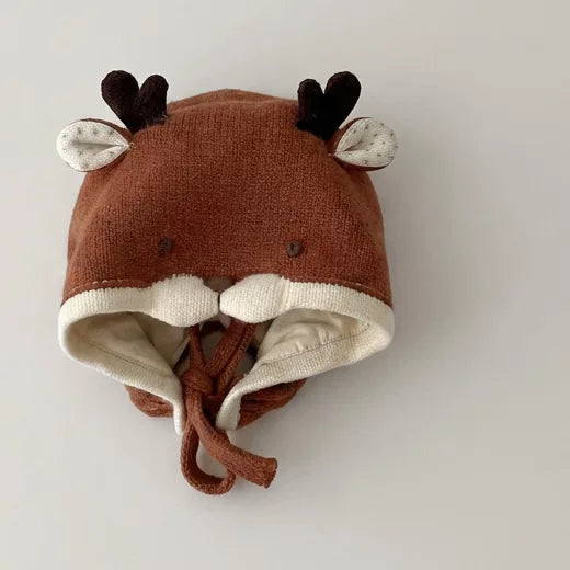 Rust knit deer baby bonnet with antlers, flat lay