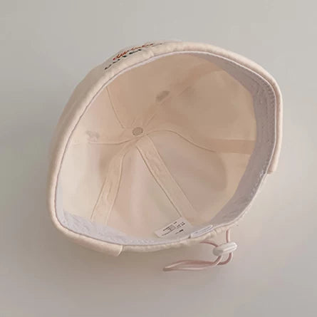 Inside of the cream frog baby hat showing the back drawstring
