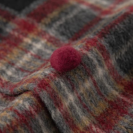 Close-up of pompom button on brushed plaid fabric