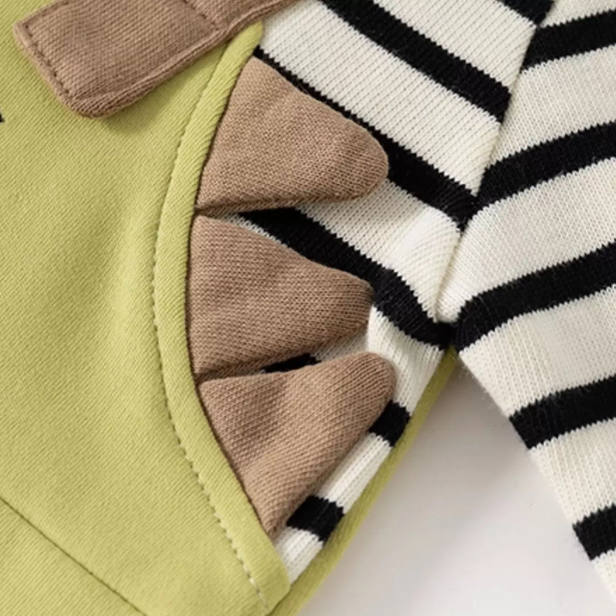 Soft felt dinosaur spikes along the side of the baby romper