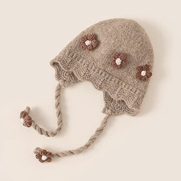 Taupe knit baby bonnet with brown crochet flowers and braided ties