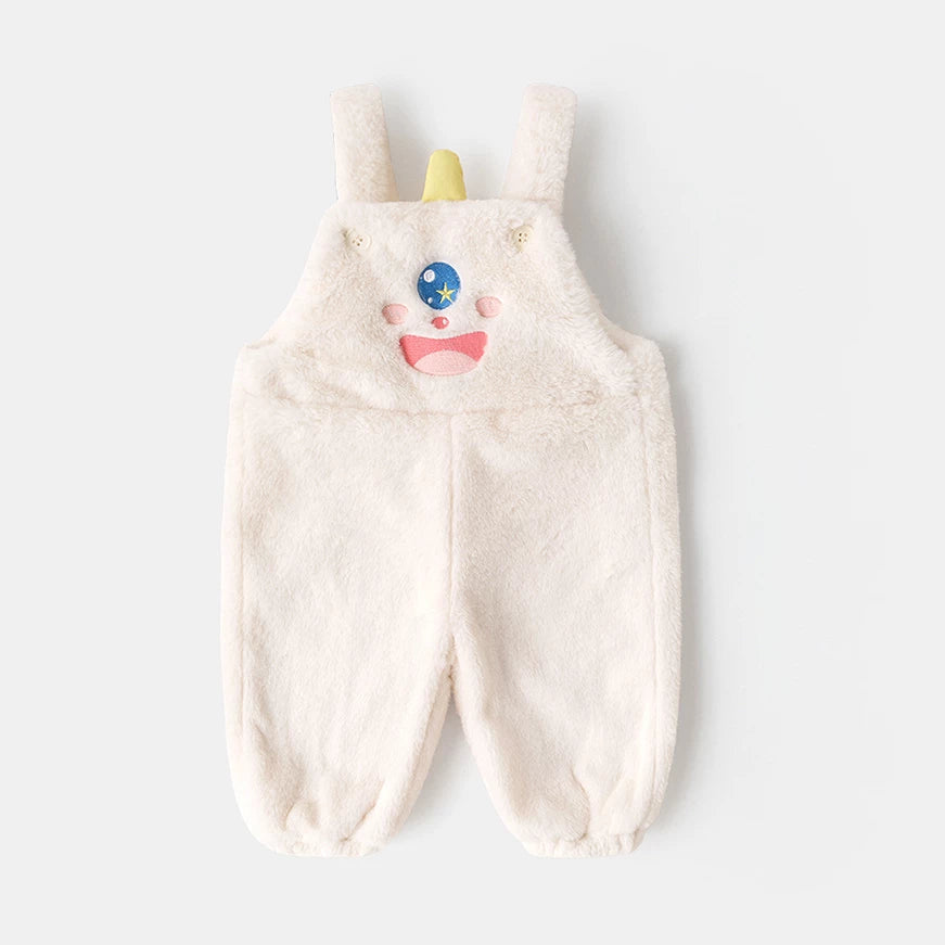 Cream plush kids overalls with a one-eyed monster face, flat lay
