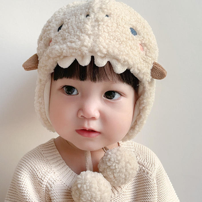 Little one in a fluffy oat dino hat and cream cardigan