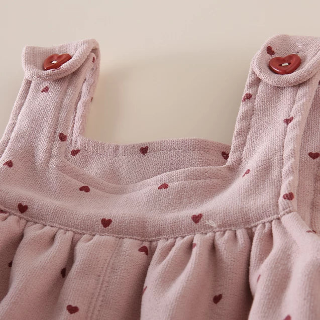 Close-up of the gathered bib and heart buttons on the rose overalls
