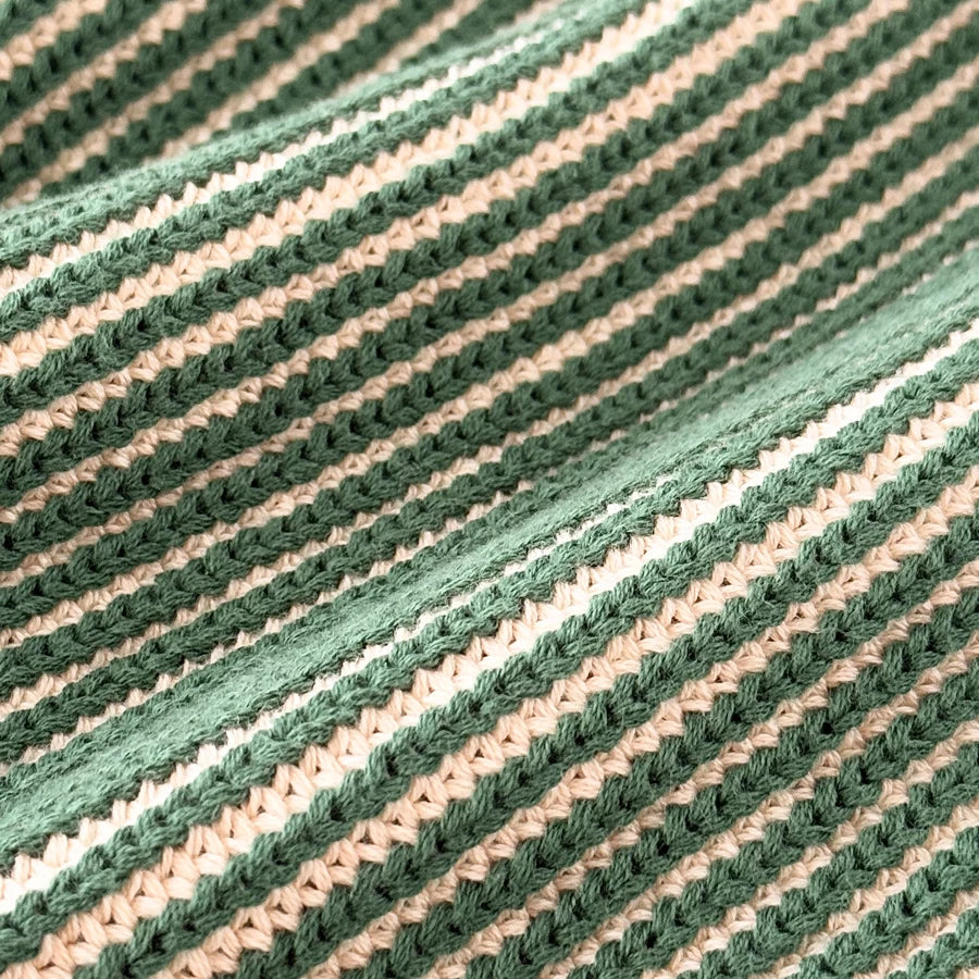 Close-up of the green and cream ribbed cotton knit