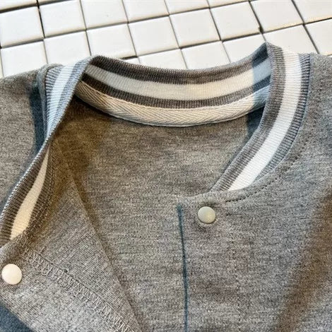 Snap-front opening and striped neckline detail on the baby romper