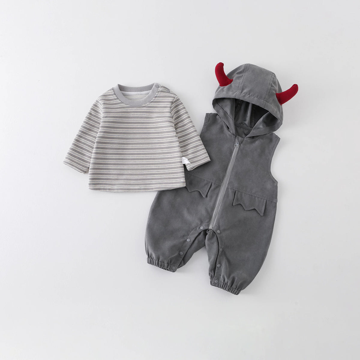 Grey hooded baby overall romper with red devil horns next to a striped long-sleeve tee, flat lay