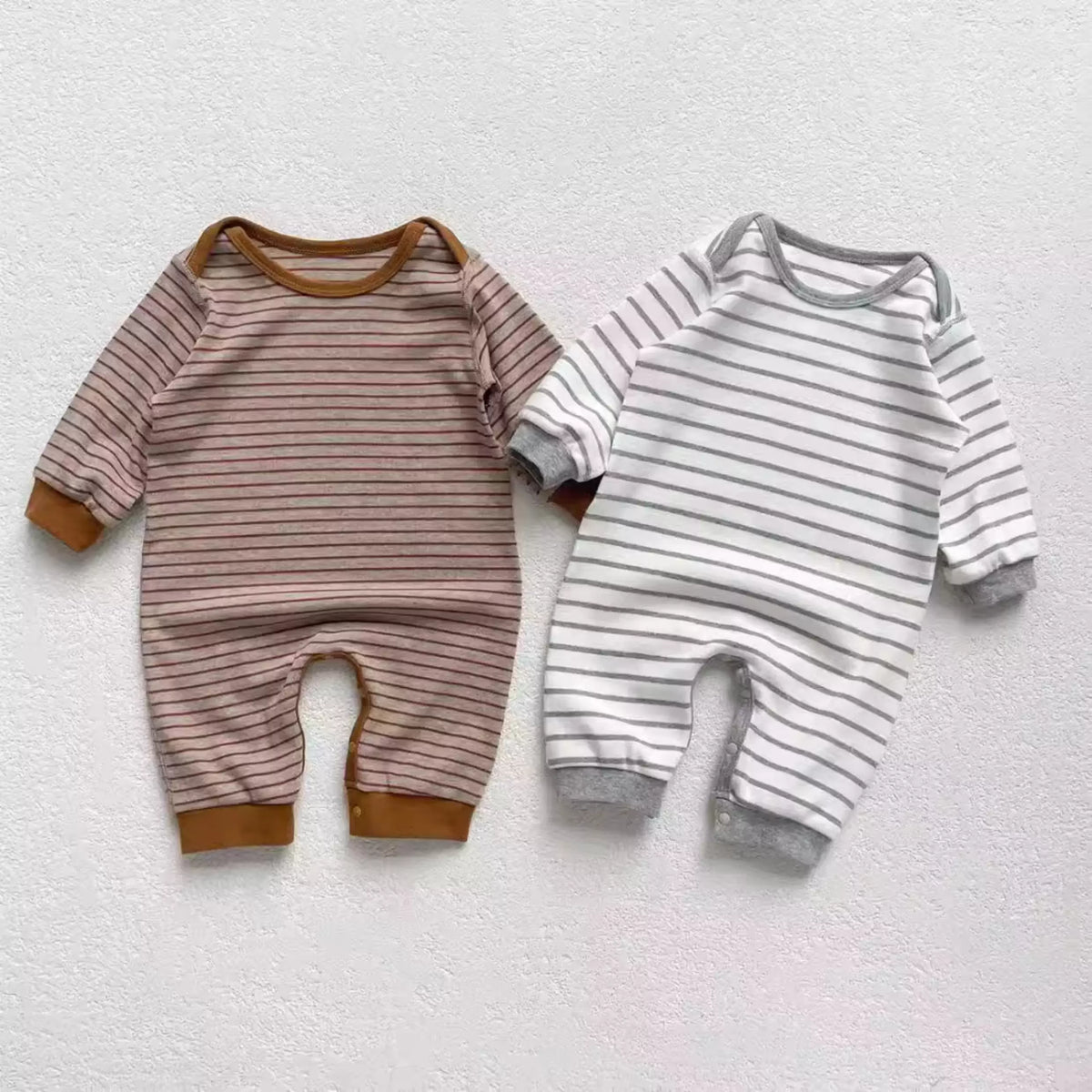 Mocha and grey striped cotton baby rompers side by side, flat lay